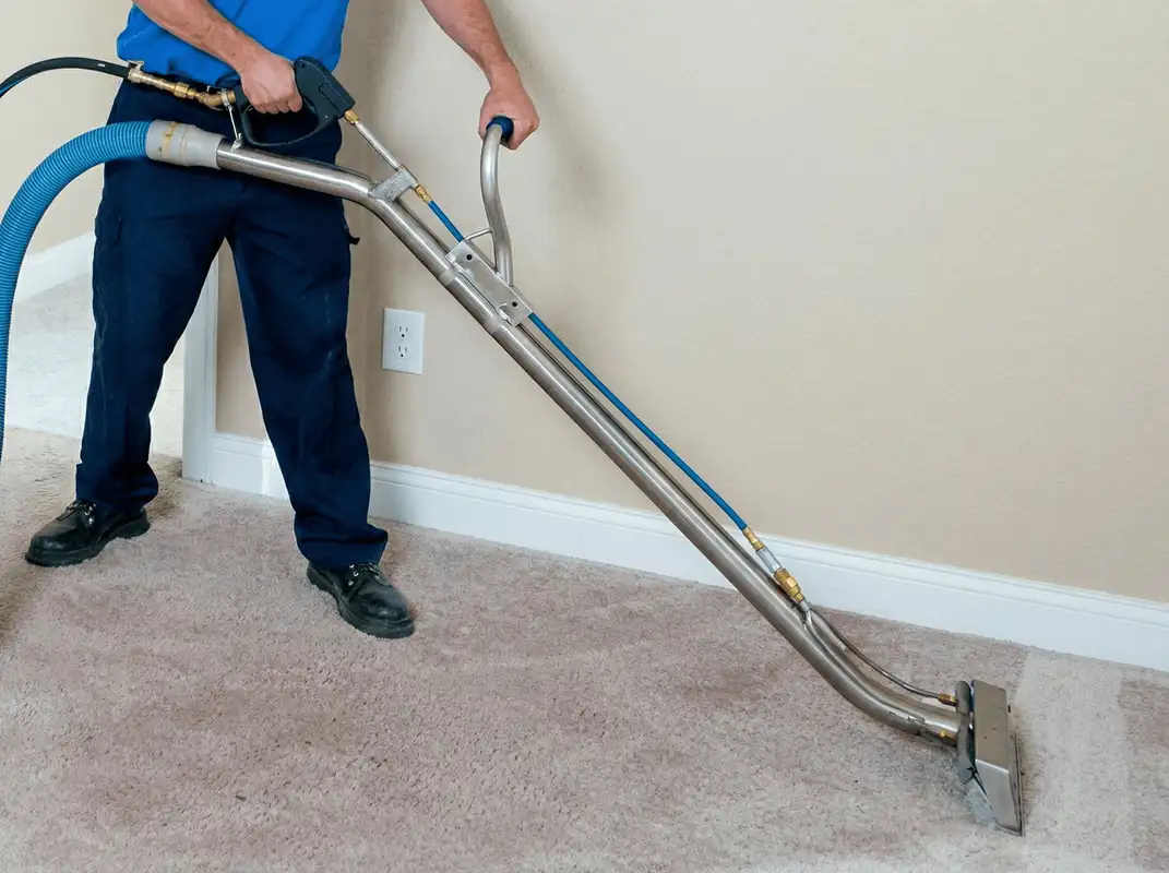 Professional operating a liquid removal machine on a carpeted floor in Kansas City, MO