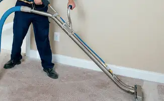 Professional operating a liquid removal machine on a carpeted floor in Kansas City, MO